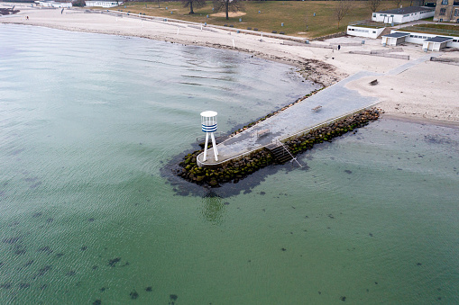 Klampenborg, Denmark - March 15, 2022: Aerial drone view of the iconic lifeguard tower at Bellevue Beach.