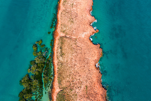 A rocky outcrop divides the blue waters in Northern Australia