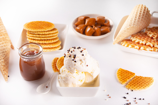 Fresh sweet ice cream with caramel sauce, waffles, cones. Summer food concept