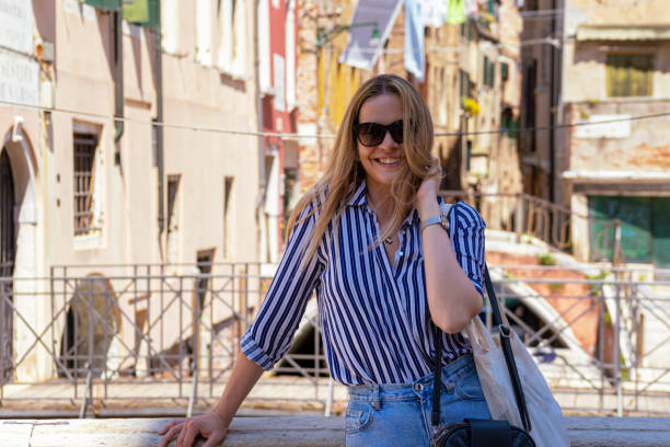 Young female tourist standing on a bridge in Venice.