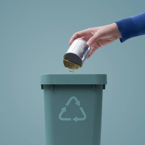 istock Woman putting a tin in the trash bin 1404178412