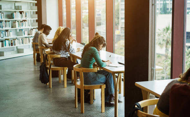 istock Young group of students studying together inside university library - Focus on center girl hand 1404178705