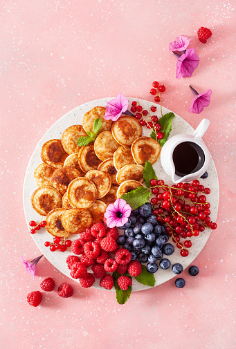 american mini pancake board with berries and maple syrup