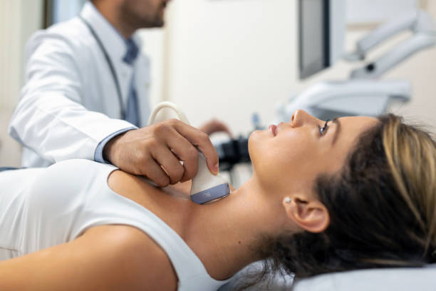 Close up shot of young woman getting her neck examined by doctor using ultrasound scanner at modern clinic Close up shot of young woman getting her neck examined by doctor using ultrasound scanner at modern clinic thyroid disease stock pictures, royalty-free photos & images