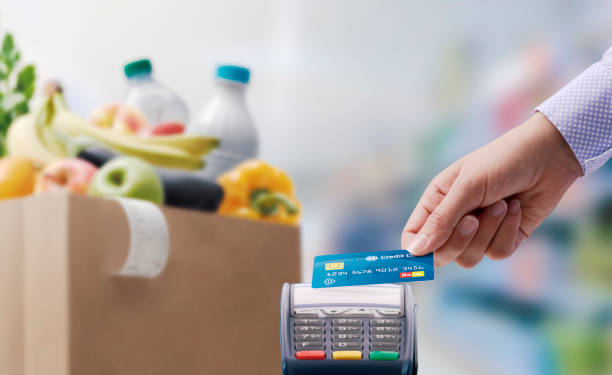 istock Woman paying for her grocery using a credit card 1404181007
