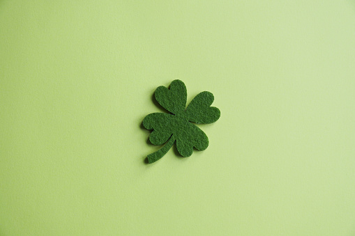 four-leaf clover made from felt on green paper background