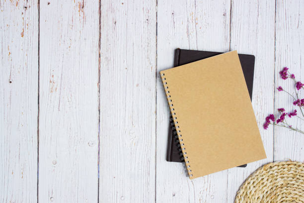 istock Brown notebook with flower over the wooden background. 1404186851