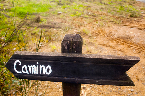 Footpath sign post, hiking pole with arrow symbol. Copy space available on the upper side of the image. A Coruña province, Galicia, Spain. Text in spanish language.