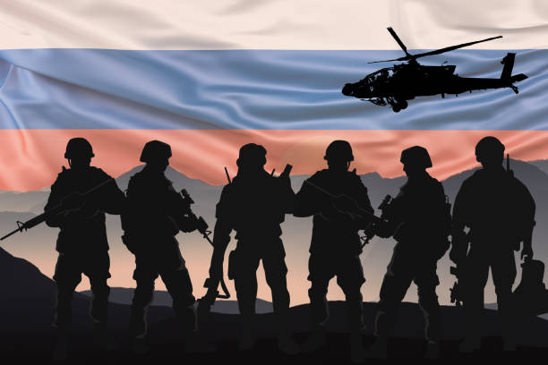 Silhouettes of soldiers with Russian flag background stock photo