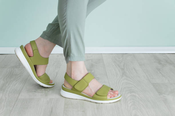 Legs of caucasian woman in green trousers and Velcro sandals. Legs of a caucasian woman in green trousers and Velcro sandals. leather clasp stock pictures, royalty-free photos & images