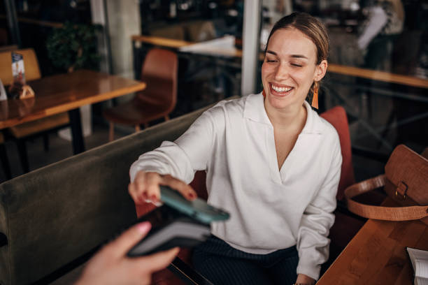istock Woman paying via smart phone 1404191675