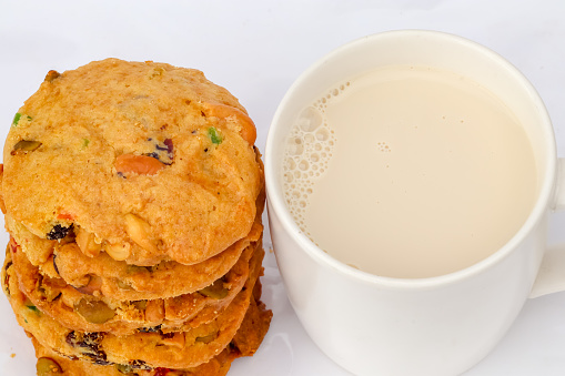 Vegan grain cookies and soil milk in white cup, top view close-up.