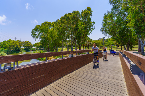Tel-Aviv, Israel - June 17, 2022: Scene of the Yarkon Park with visitors walking and cycling, Tel-Aviv, Israel