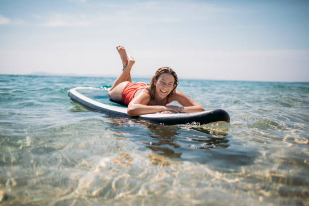 istock Smiling woman floating on her paddle board 1404196889