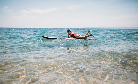 Photo of woman standing up on SUP board.