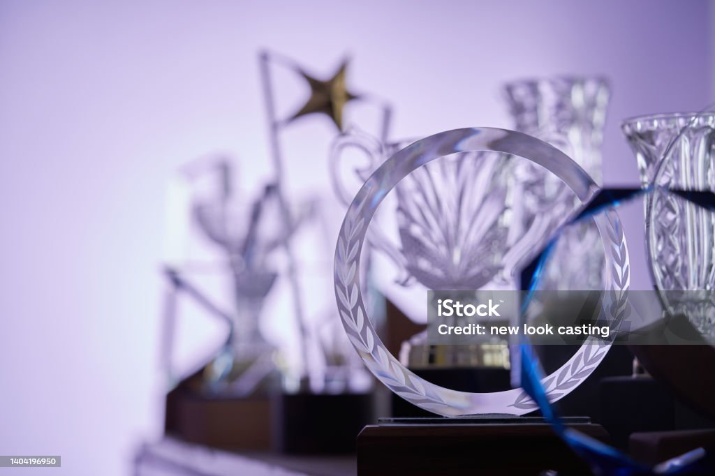 group of  crystal trophies against purple background Award Stock Photo