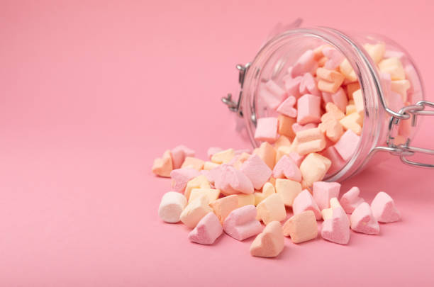 istock Marshmallows in a glass jar on a pink background. Chewing candy close-up. Snacks and snacks for parties. Spice for coffee and cocoa. Winter food concept. Space for text. Place to copy. 1404197728