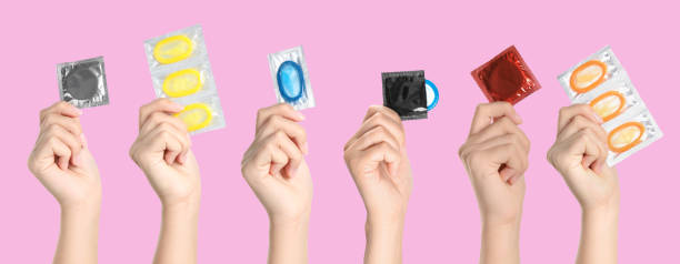 분홍색 배경에 콘돔을 들고 여성의 사진과 콜라주, 근접 촬영. 배너 디자인 - condom sex sexually transmitted disease aids 뉴스 사진 이미지