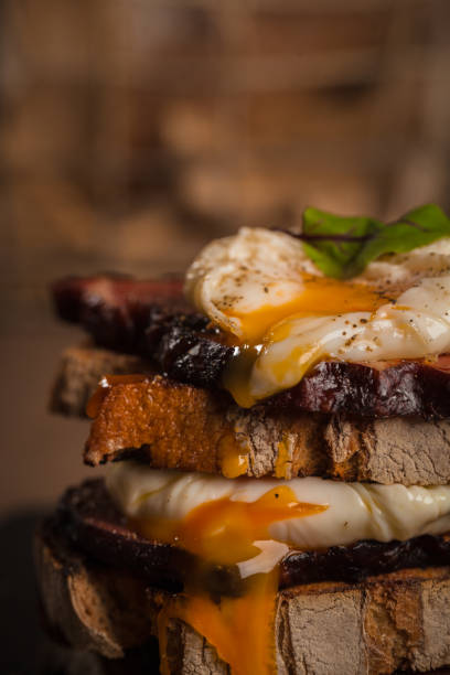 istock Pile of toasts with fried egg and bacon 1404198735