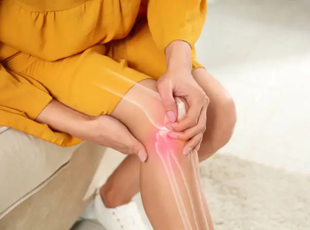 Photo of Sick woman at home, closeup. Digital compositing with illustration of knee joint