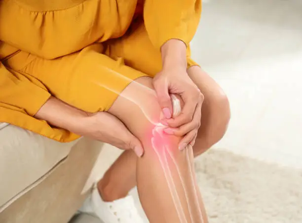 Sick woman at home, closeup. Digital compositing with illustration of knee joint