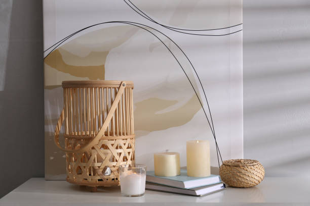 istock Burning scented candles and books on white table near light wall 1404199180