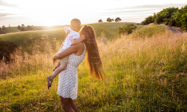 istock Happy mother with her son having fun in the field at sunset 1404199216