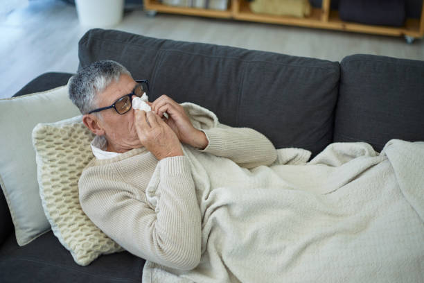 istock Senior man blowing his nose 1404200769
