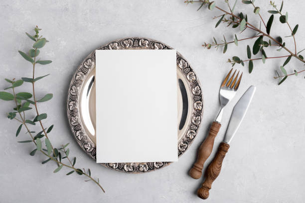 istock Wedding invitation card mockup 5x7 on silver retro vintage plate on grey background with eucalyptus, Menu card mockup 1404200796
