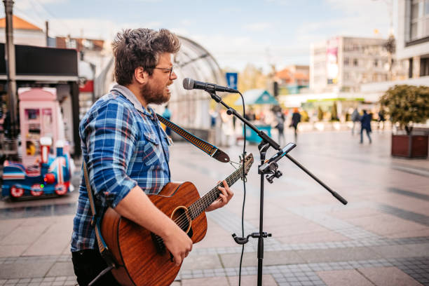 gitarrist auf einem stadtplatz - street musician stock-fotos und bilder