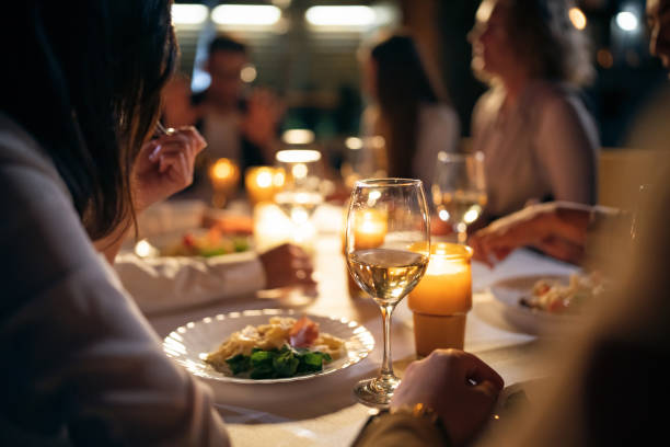 レストランのバルコニーで夕食をとる、認識できない多人種の女性と男性の友人 - レストラン ストックフォトと画像