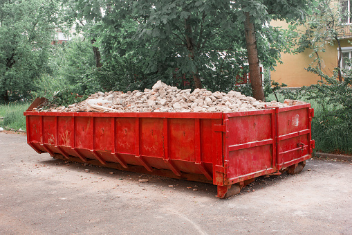 Red container with solid domestic and construction waste.