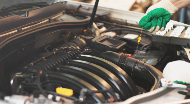 istock Checking the engine oil level by a mechanic in a car service 1404206721