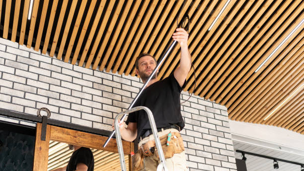 istock A male construction worker changes LED lamps on a pine plank wooden ceiling. Installation of a designer ceiling made of wooden planks in the loft style. An electrician installs electrical wiring. 1404208630