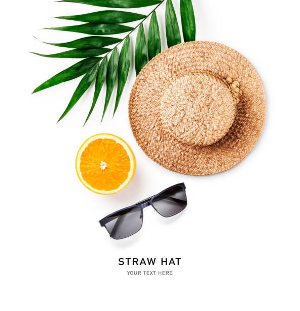 istock Straw hat, sunglasses, orange and palm leaf on white 1404209269