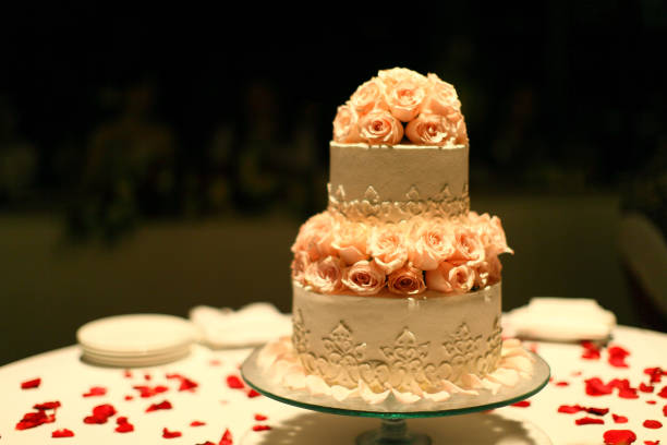 istock Pink rose wedding cake on white table with red petal rose 1404209593