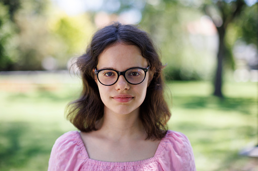 Close-up portrait of a smiling girl with eyeglasses looking at the camera