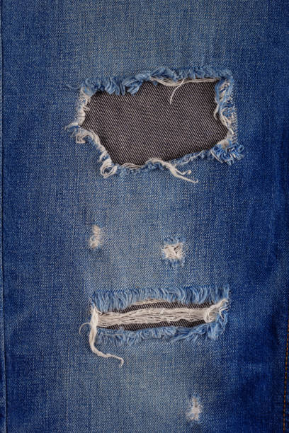 istock Blue jeans denim background texture. Torn jeans fabric material surface 1404212358