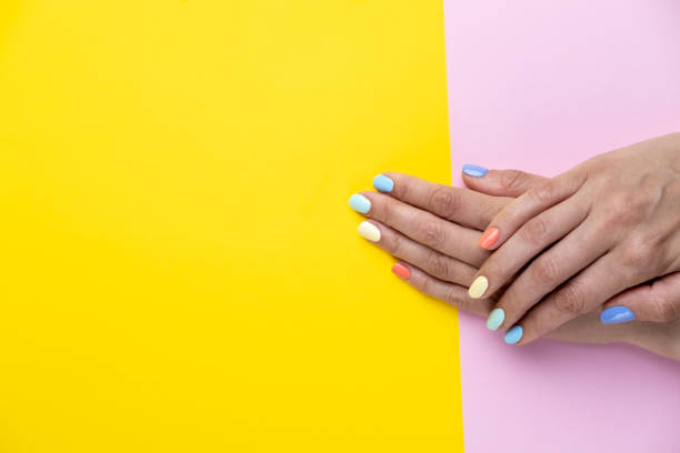 istock Pastel manicure close up on pink an yellow background. 1404213850