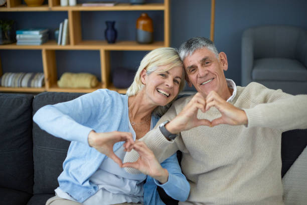 istock Cute older couple making heart sign with their hands 1404217388