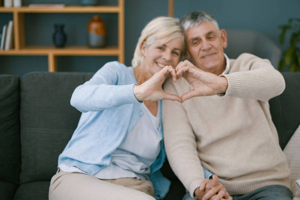 istock Cute older couple making heart sign with their hands 1404217456
