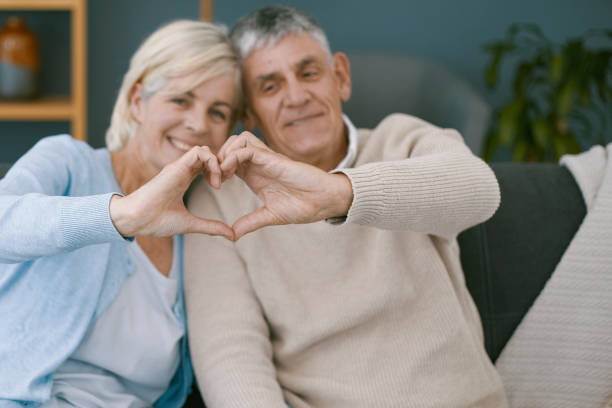 istock Cute older couple making heart sign with their hands 1404217468