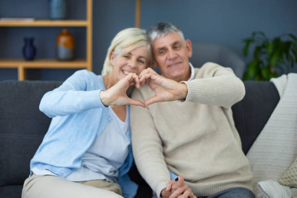 istock Cute older couple making heart sign with their hands 1404217469