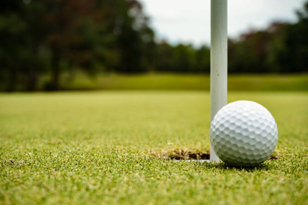 draufsicht auf einen golfball auf grünem platz am loch. - the game of operation stock-fotos und bilder