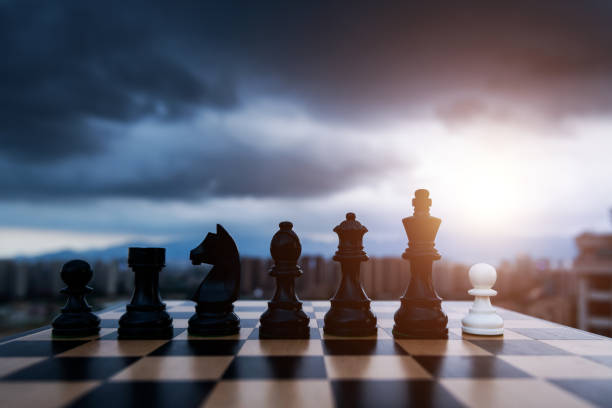istock White chess pawn and black pieces on chess board 1404218667
