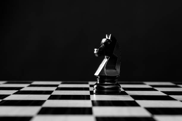 istock Black knight chess piece on black background 1404218751