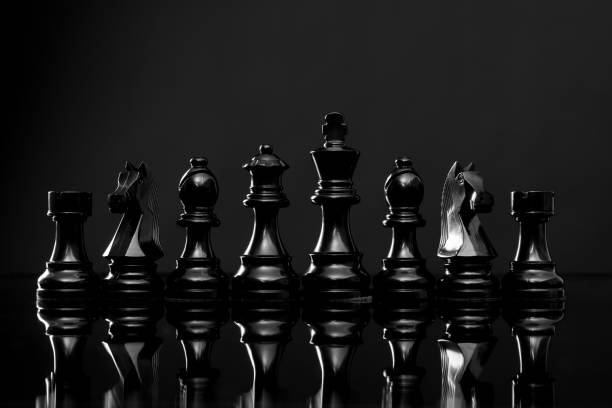 A row of chess pieces on black background