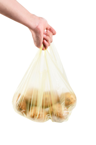 Shopping concept, Hand holding potatoes in plastic bag isolated on the white background with clipping path