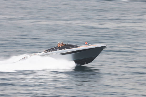 Glamorous hi-flying couple enjoying the luxury lifestyle as they speed along in their powerful speed boat in Gibraltar stock photo