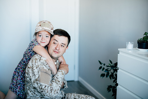 Military man father hugs daughter. Portrait of happy american family